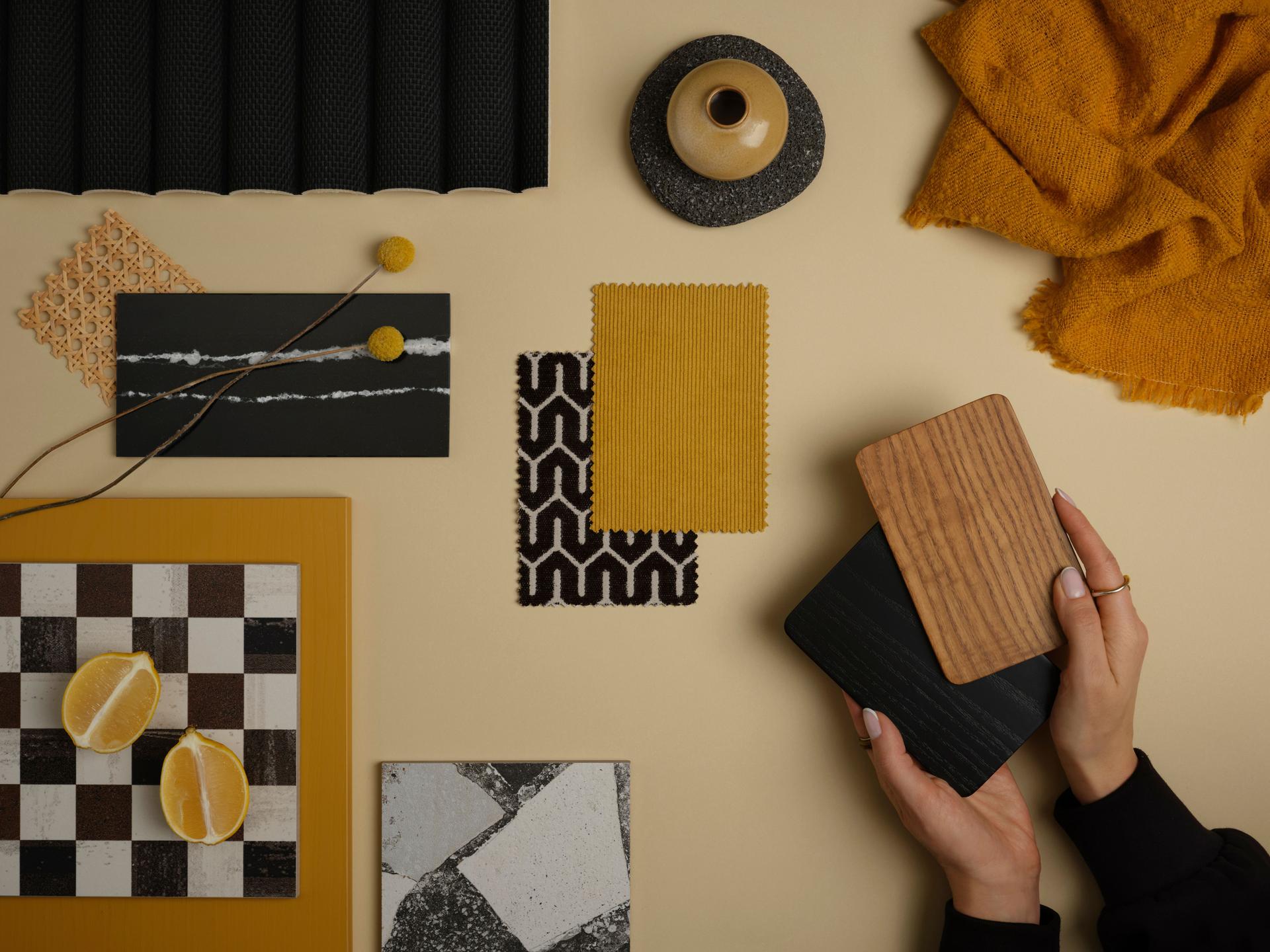 A mustard yellow and black contrast mood board with geometric patterns, wood samples, and natural textures, bringing warmth and depth.